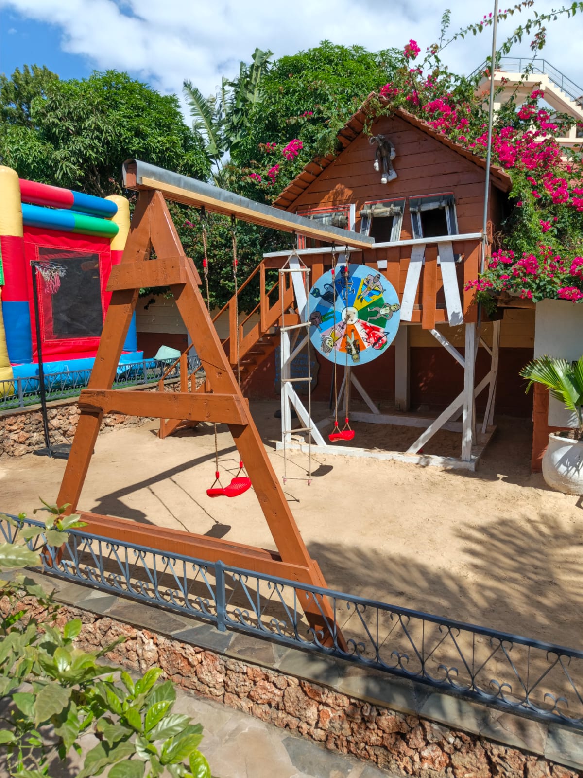 Kids wooden playhouse and swings on sand